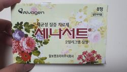 옅은 노란색의 꽃무늬 바탕을 가진 사각형의 종이곽 안에, 세나서트라는 글자가 표시되어 있다.