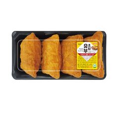 유부초밥 네 개가 검은색 플라스틱 용기에 담겨져 있다.